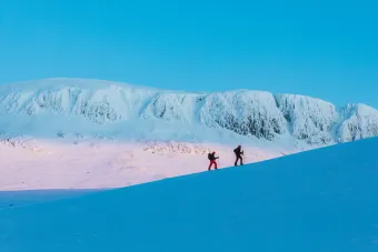 människor som går på ett snöigt berg